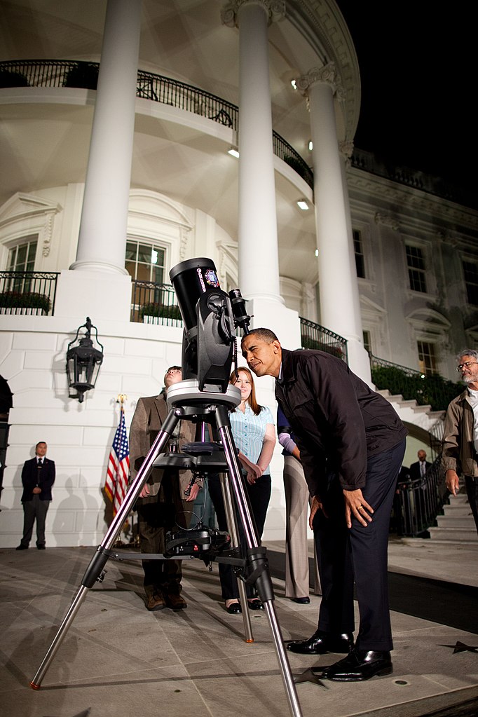 Barack Obama mira a través de un telescopio celestron (PD)